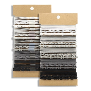 Close-up of multi-textured elastic hair ties in grey tones on cardboard display
