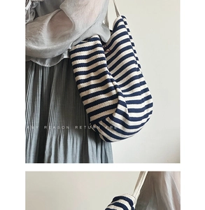Detail of navy striped canvas tote bag featuring cotton rope handles and red embroidery