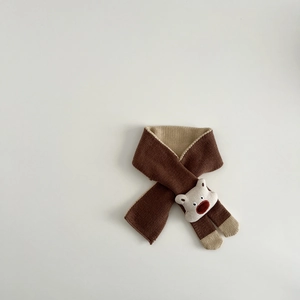 Close-up of brown knit scarf featuring a cute 3D bear decoration and soft texture