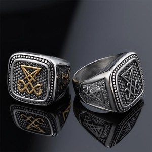 Macro view of Sigil of Lucifer rings in silver and gold-tone steel on mirror surface
