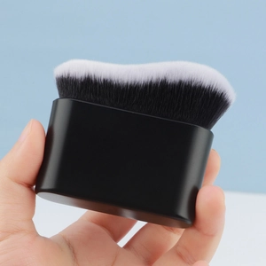 Macro view of wave-shaped foundation brush with dense black and white synthetic bristles