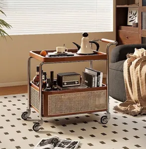 Detail of solid wood tray and rattan storage basket on a rolling stainless steel trolley
