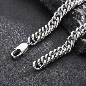 Vue macro d'un collier en maille gourmette en acier titane argenté avec fermoir mousqueton