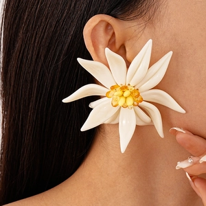 Close-up of oversized resin flower earrings with white petals and amber beaded centers