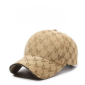 Detail of beige baseball cap with repeating letter pattern and black brim edging