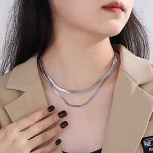 Silver double-layer flat snake bone chain necklace shown on a model neck