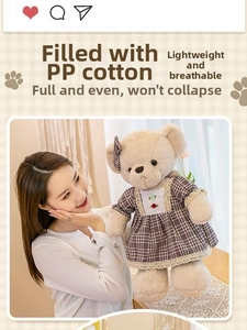 Detailed view of plush teddy bear wearing brown plaid dress and matching bow