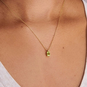 Close-up of a 18K gold-plated titanium necklace with a green rectangular zircon pendant