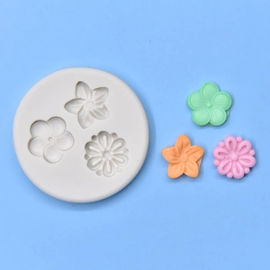 Macro detail of round silicone mold with three flower shapes and finished resin samples