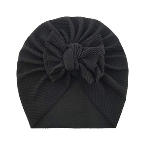 Soft black ribbed baby turban hat featuring a large decorative bow on a white background