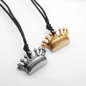 Close-up of gold and silver crown pendants on black cords with detailed textures