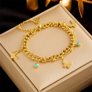 Detail of gold double-layer butterfly bracelet with turquoise charm on jewelry box