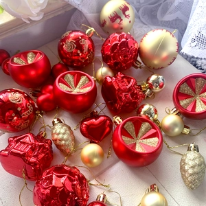 Detail of red and gold Christmas ornaments including heart, house, and pinecone shapes