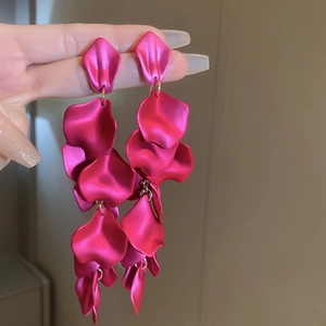 Detailed macro view of magenta layered petal tassel earrings with matte finish design