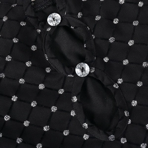 Détail d'une robe en résille noire avec paillettes argentées et double boutonnage