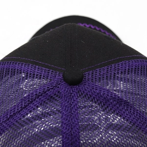Close-up of the black cotton crown and purple mesh back of a breathable trucker hat