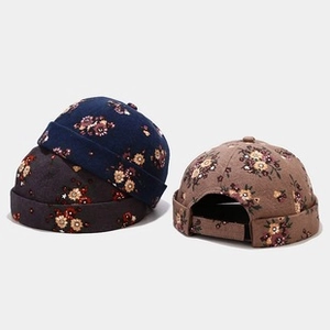 Detail of floral brimless caps with adjustable straps in navy, grey, and khaki colors