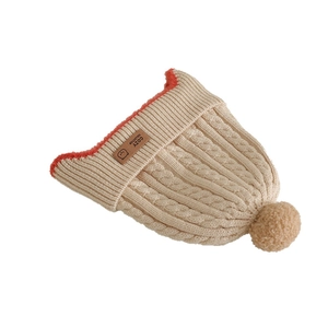 Beige cable knit baby beanie with faux fur pom and cozy fleece lining for winter warmth