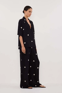 Detail of black polka dot chiffon shirt and wide leg trousers set on female model