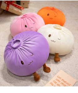 Close-up of cute plush bun pillows in purple, pink and white on a soft cream rug