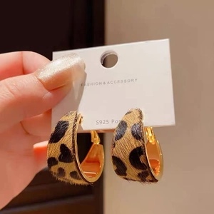 Close-up of C-shaped leopard print earrings with gold metal edges and S925 silver posts