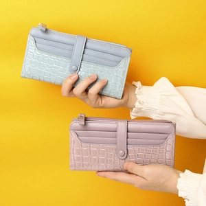 Elegant long women's purse with crocodile pattern in light blue and soft pink colors