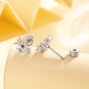 Silver star earrings with iridescent zircon and secure screw back closure on beige background