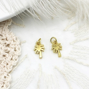 Macro shot of gold palm tree charms with connector rings for DIY jewelry making