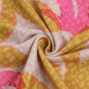 Makroaufnahme von Strickstoff mit abstrakten geometrischen Mustern in Pink und Gelb