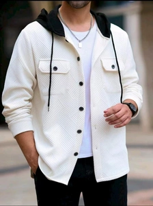 Detail of ivory hooded shirt jacket showing jacquard texture and black chest buttons