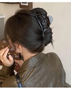 Détail de la grande pince à cheveux noire brillante en forme de cœur sur tête