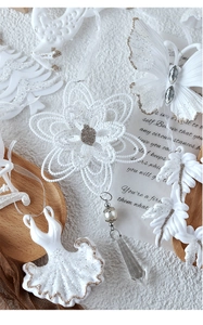 Close-up of white glittery Christmas acrylic ornaments with beads and ribbon detail