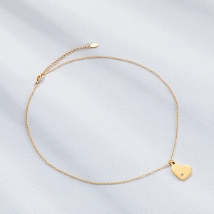 Détail du pendentif coeur en acier doré poli miroir avec un petit diamant incrusté