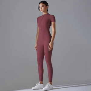 Side view of mauve short sleeve one piece yoga jumpsuit with zipper neck and slim fit texture