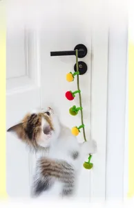 Catnip toy with colorful felt balls and bell hanging on door handle for active kittens