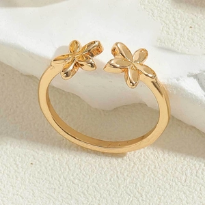 Macro detail of gold plated flower ring showing dual floral petals and polished finish