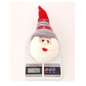 Embrasse de rideau en peluche Père Noël pesant 56g sur une balance numérique