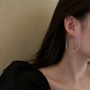 Chic silver hoop earrings with sparkly rhinestones on model for a trendy fashion look