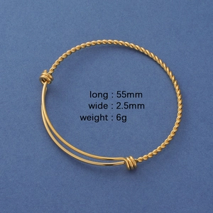 Detailed top view of a 55mm golden twisted wire stainless steel cuff bracelet on blue background