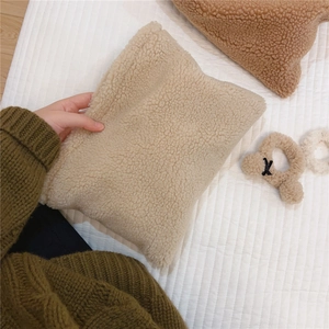 Close-up of soft creamy white faux lamb wool makeup bag with fuzzy texture details