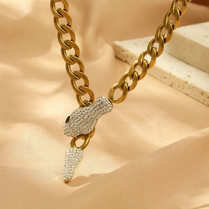 Macro shot of gold snake-shaped pendant with sparkling pavé crystals on thick chain