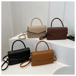 Four elegant minimalist crossbody bags in different colors with stud detailing on the flap