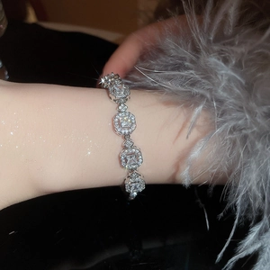 French palace style emerald bracelet with diamonds worn on wrist with feathers
