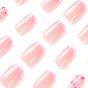 Glossy pink French press-on nails with dark pink heart patterns in various sizes