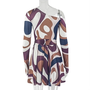 Close-up of abstract print on a one-shoulder long sleeve mini dress with a fitted waist