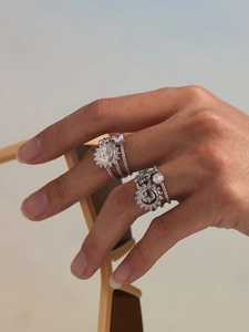 Detail of silver sun and moon rings with 5A green zircon inlays on female hand