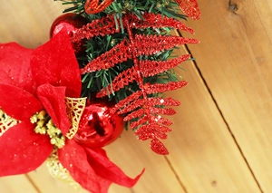 Detailed close-up of 40cm Christmas wreath with red poinsettias and ornaments on wood