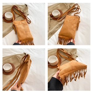 Close-up of brown suede hobo bag with long fringe tassels and knotted shoulder strap