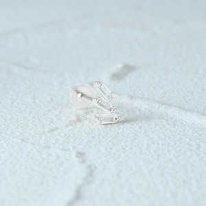 Macro shot of silver S925 stud with three rectangular zircons on white stone