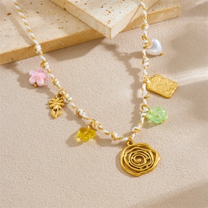 Collier en corde tressée blanc et or avec pendentifs fleurs et cœurs sur support pierre